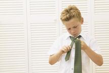 young boy tying tie