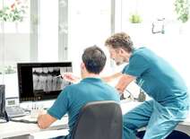 Two dental team members looking at xray