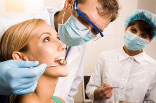 Patient being examined by dentist and assistant 