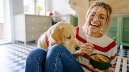 woman eating with her dog