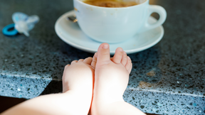 baby feet and a coffee cup on counter