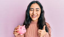 Ortho patient smiling with piggy bank