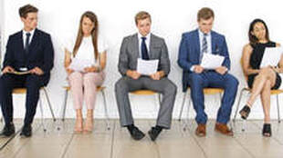 People dressed in business attire sitting in hallway